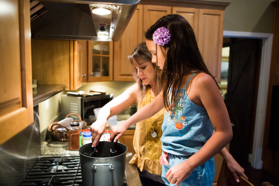 mother and daughter cooking on stove