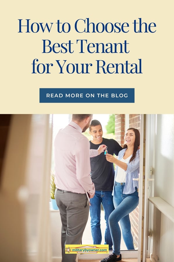 couple standing in a doorway receiving keys from a gentleman to their new home