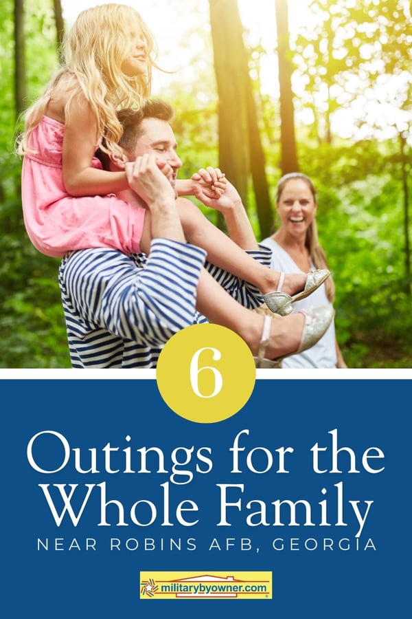 Family of three smiling as they walk through woods with text, 6 Outings for the Whole Family Near Robins AFB, Georgia