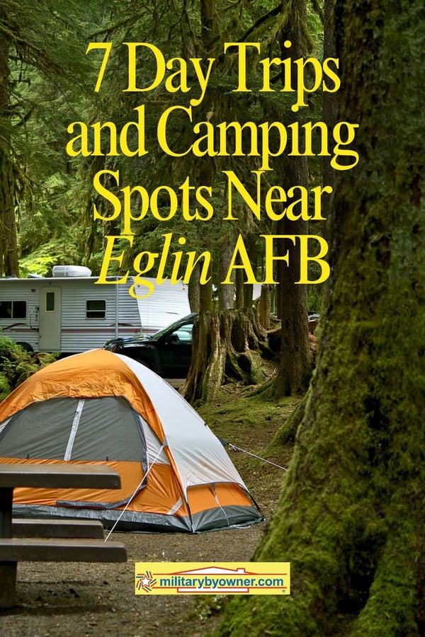 View of orange tent and white camper in woods with trees and moss with text, 7 Day Trips and Camping Spots Near Eglin AFB