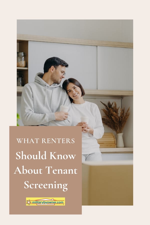 Couple wearing neutral clothing stand side by side leaning on each other in kitchen with cups of coffee in hand surrounded by moving boxes with text, What Renters Should Know About Tenant Screening