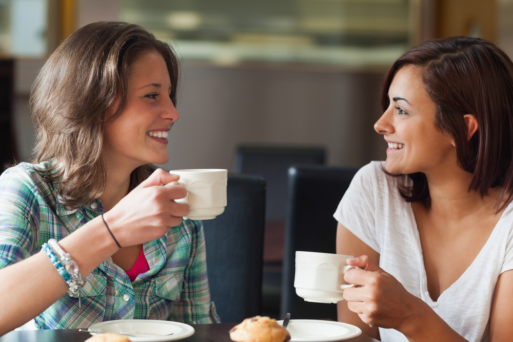 Two smiling students having a cup of coffee in college canteen-1