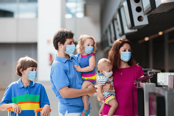 family wearing masks at airport