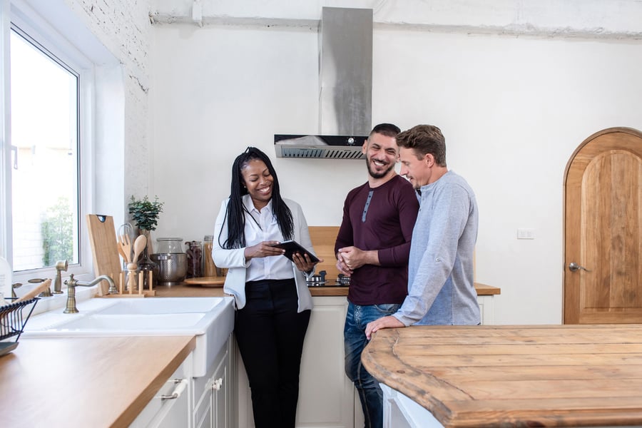 landlord and tenants looking at tablet in rental home kitchen