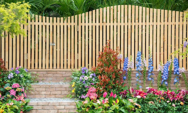 decorative wooden fence and flowerbeds