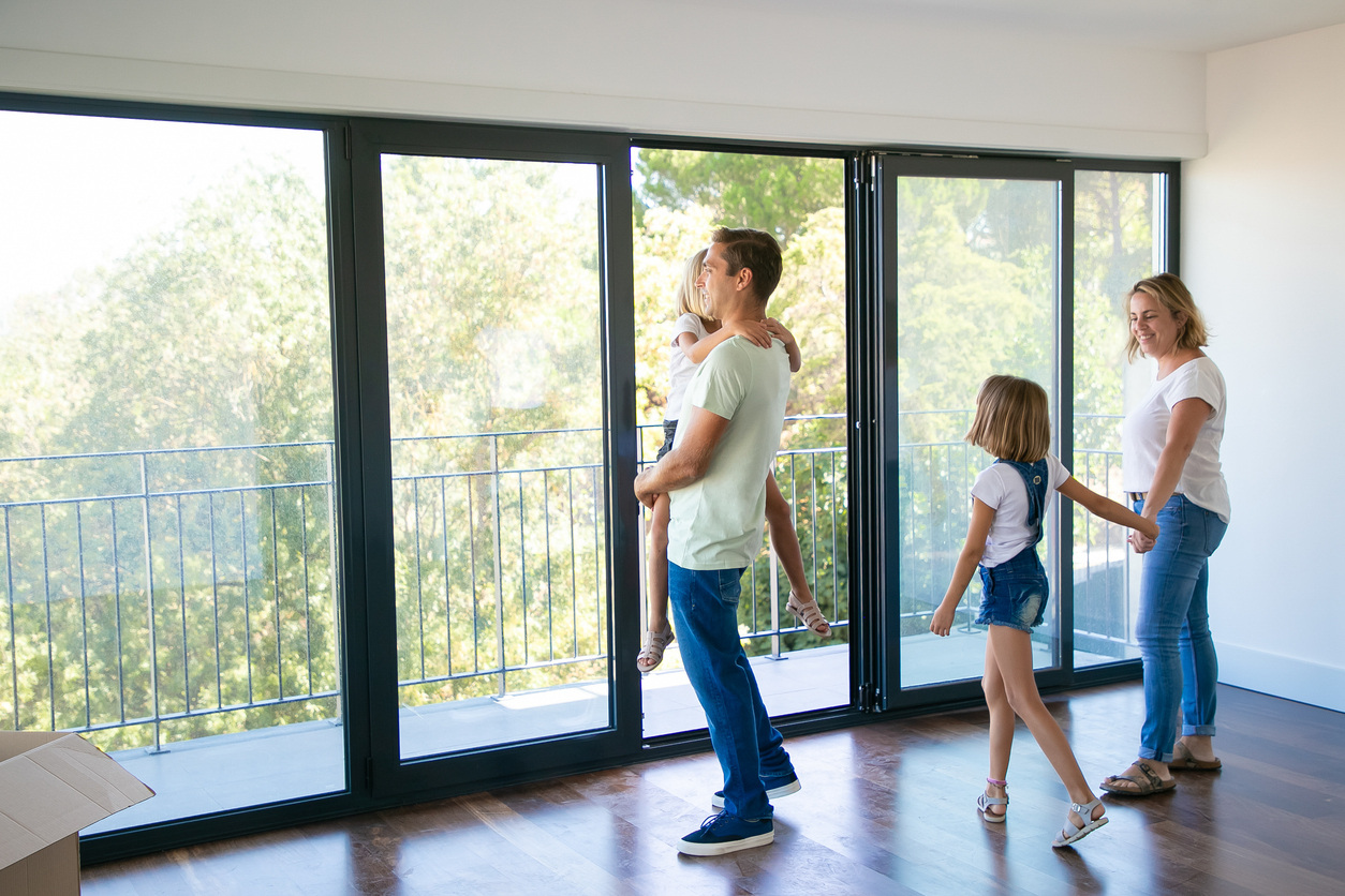 family looking out window of empty apartment