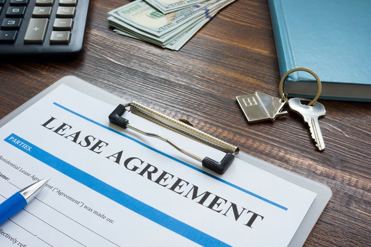 residential lease agreement, house keys, cash, calculator, and book