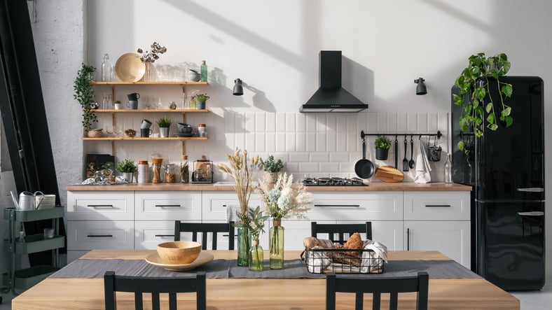 kitchen with wooden table, plants, and open shelving