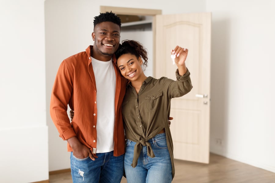 young couple holding keys to new home