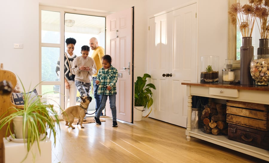 family walking with dog into home