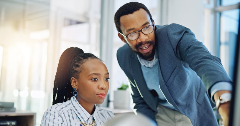 business mentor showing young woman computer screen