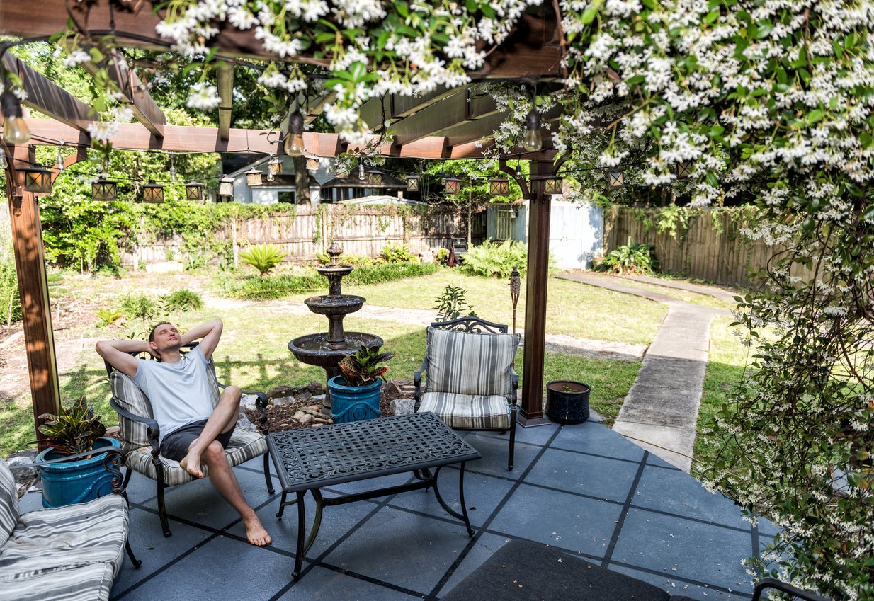 man reclining in shade under pergola