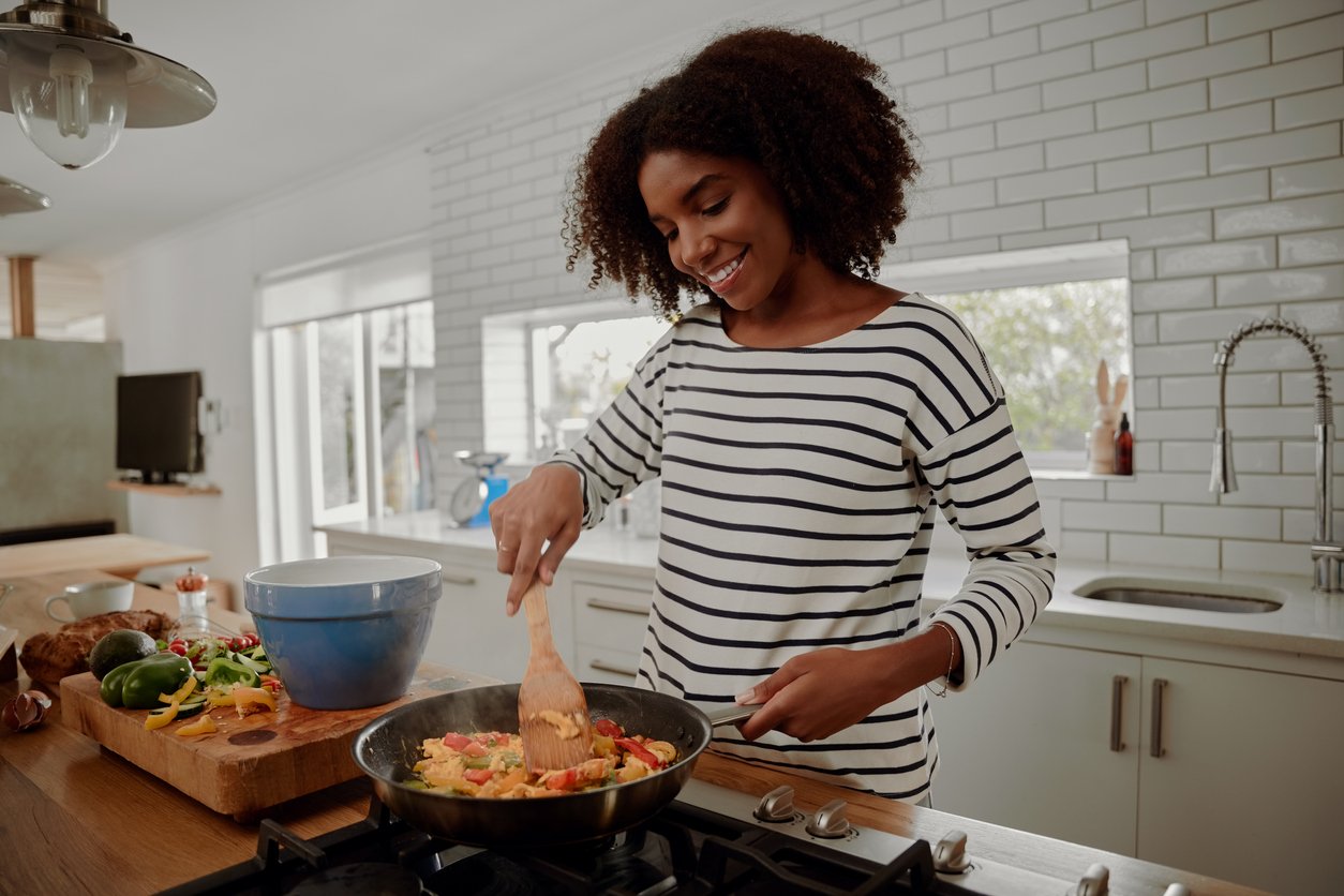 woman cooking in gourmet kitchen which many homebuyers want