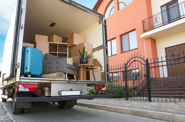 moving van filled with boxes in front of apartment building