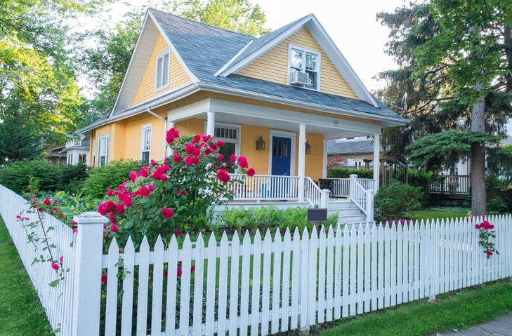 yellow home with white picket fence