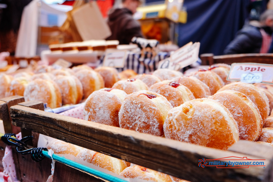 Photo of sugar donuts with jelly filling on trays at a donut shop. 