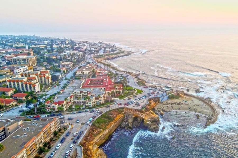 Aerial view of La Jolla Cove with downtown La Jolla and beach in background red roof 