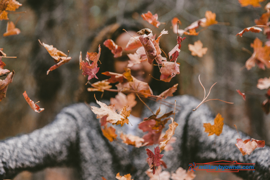 woman throwing leaves into the air