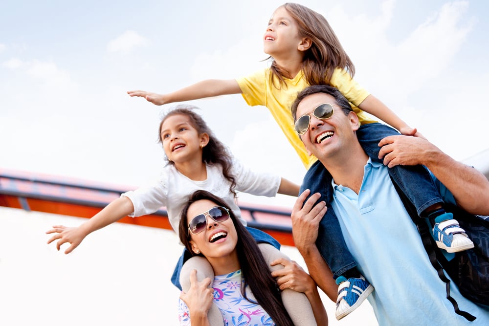 parents with young children on shoulders happy and leaving airplane