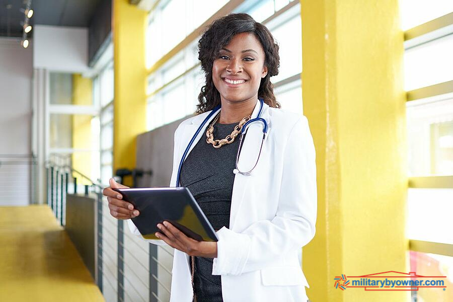 woman in lab coat with stethescope and notebook