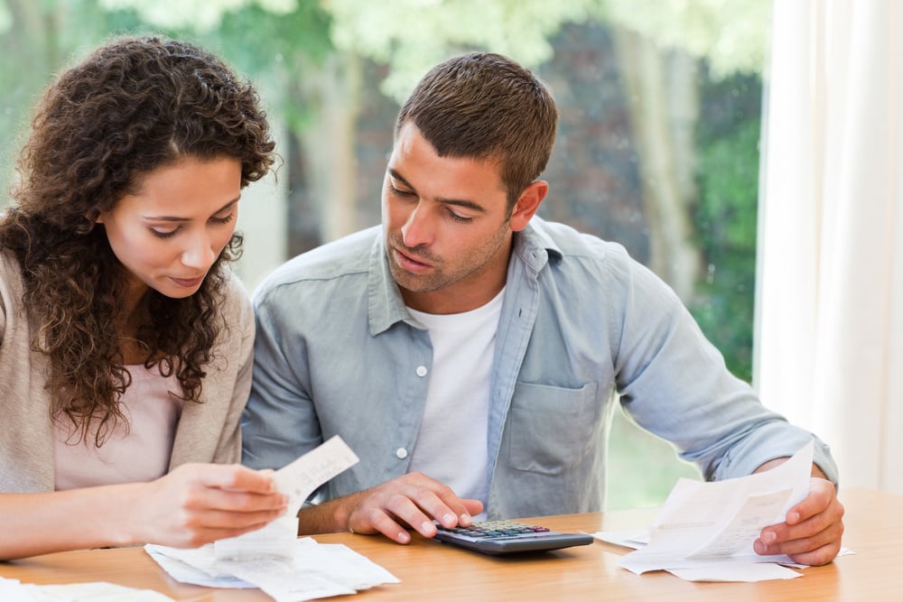 couple looking at paperwork and calculator