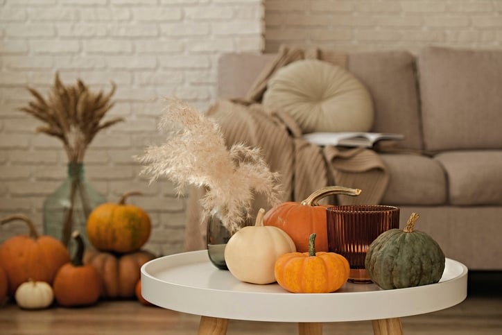 arrangement of pumpkins and candle on tray showcasing fall decor